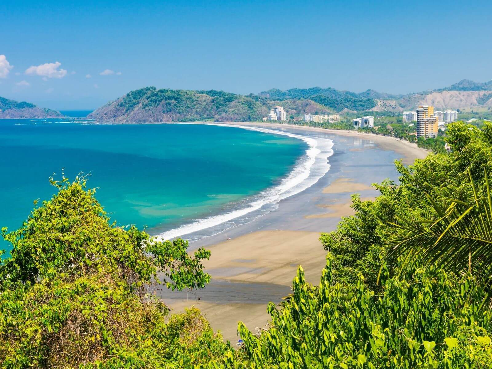http://Scenic%20view%20of%20Jaco%20Beach%20framed%20by%20tropical%20foliage,%20ideal%20photo%20stop%20on%20a%20Private%20Costa%20Rica%20airport%20transportation%20service